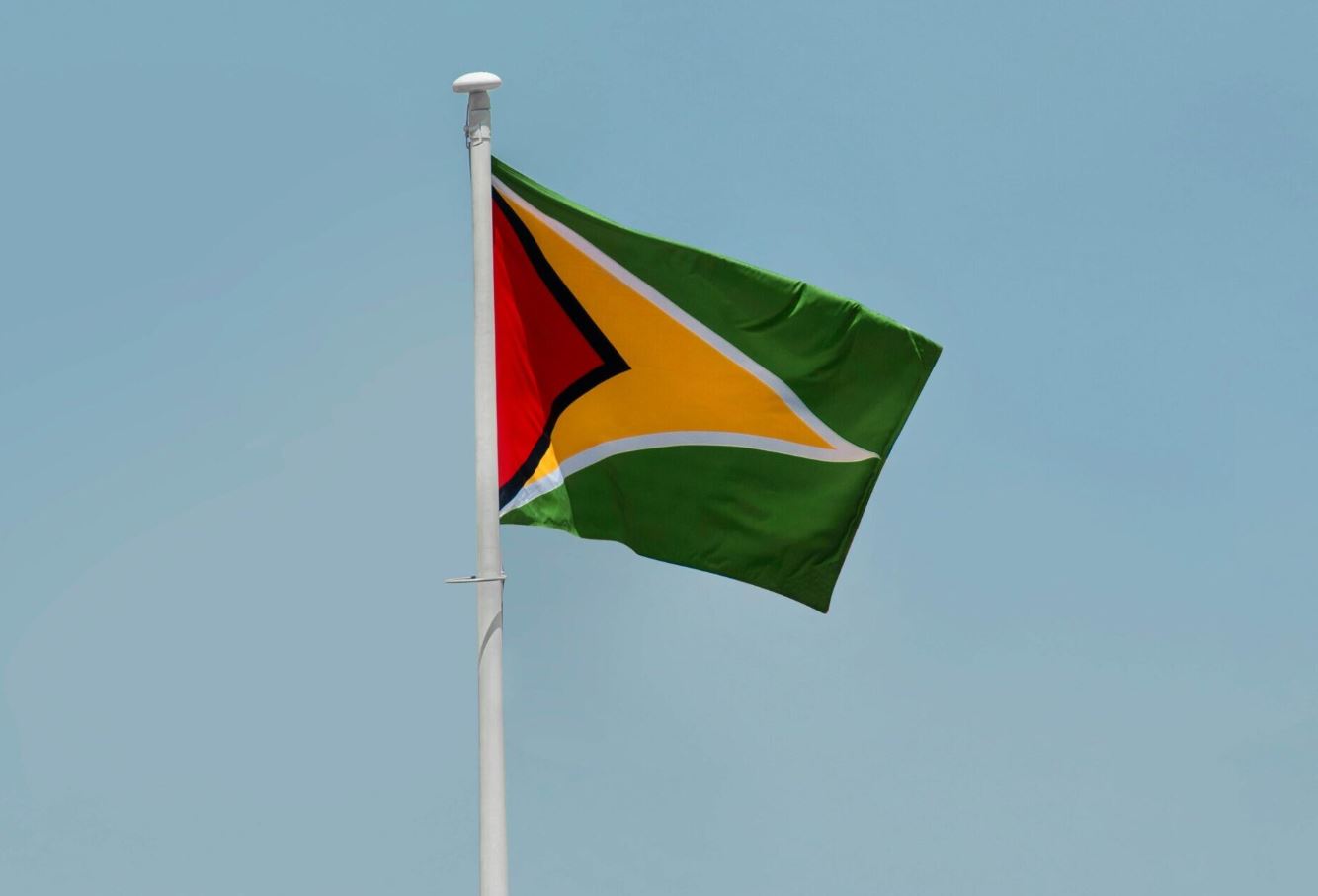 Ý nghĩa cờ Guyana: Mũi tên vàng biểu thị sự giàu có khoáng sản và một tương lai tươi sáng